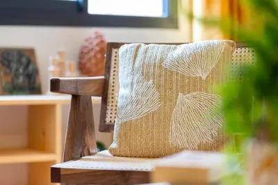 a wooden chair with a throw pillow on it at Marrakech Oasis, Central and Modern in Marrakech