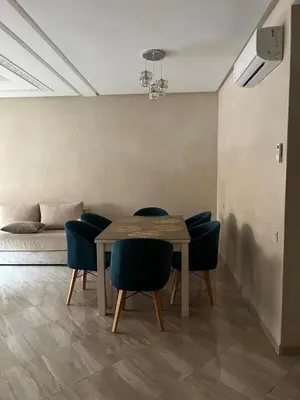 a dining room with a table and chairs and a bed at jnane awrad du 18 novembre in Marrakech