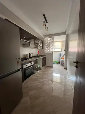 a large kitchen with a stove and a refrigerator at jnane awrad du 18 novembre in Marrakech