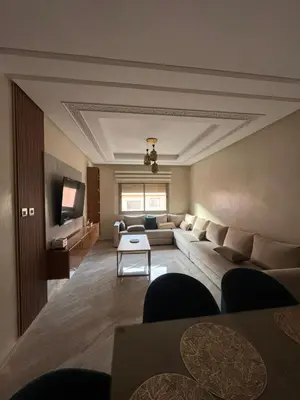 a living room with a couch and a tv at jnane awrad du 18 novembre in Marrakech