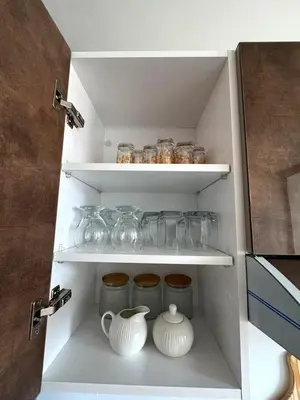 a white cabinet with jars and vases in it at jnane awrad du 18 novembre in Marrakech