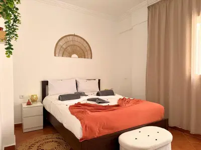 a bedroom with a bed with an orange blanket on it at Le Cosy Nejmaa - Piscine - 4 Prs - Marrakech in Marrakech