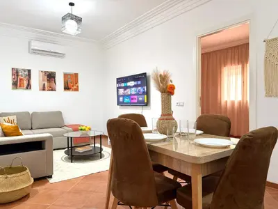 a living room with a table and a couch at Le Cosy Nejmaa - Piscine - 4 Prs - Marrakech in Marrakech
