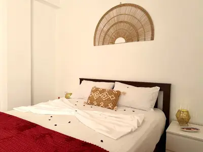 a bed with white sheets and a red blanket at Le Cosy Nejmaa - Piscine - 4 Prs - Marrakech in Marrakech