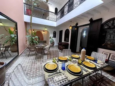 a dining room with a table with yellow plates on it at Charming private riad with pool in Marrakech
