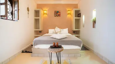 a small bedroom with a bed and a table at Riad L'EncensOriental & Spa in Marrakech