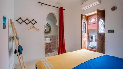 a bedroom with a bed and a door with a window at Riad L'EncensOriental & Spa in Marrakech