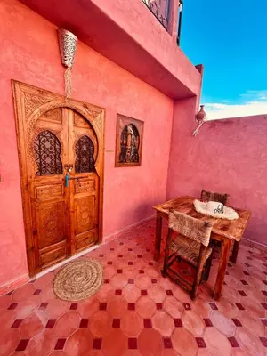 a room with a wooden door and a table and chair at Riad L'EncensOriental & Spa in Marrakech
