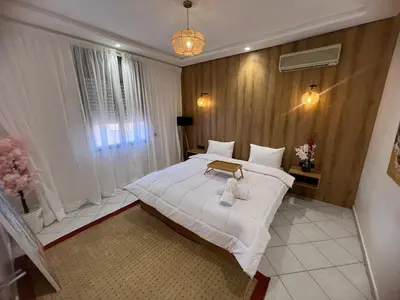 a bedroom with a large white bed in a room at Cozy appartement au centre de marrakech in Marrakech