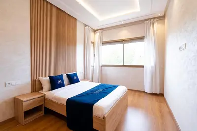 a bedroom with a large bed with a window at Petit Palm in El Rhechat