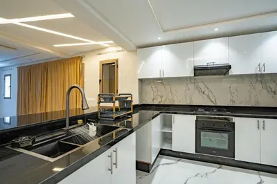 a kitchen with white cabinets and a sink at Petit Palm in El Rhechat