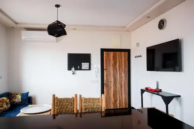 a living room with a wooden door and a tv at Marjane Allal Fassi 2 chambres Bedrooms 2 Bathrooms Wi-Fi fibre climatisation in Marrakech