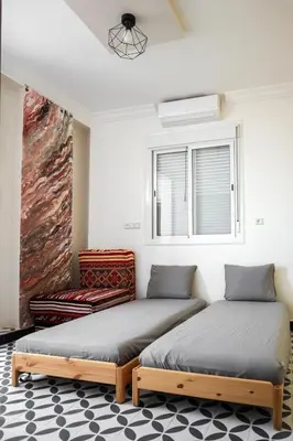 two beds sitting in a room with a window at Marjane Allal Fassi 2 chambres Bedrooms 2 Bathrooms Wi-Fi fibre climatisation in Marrakech