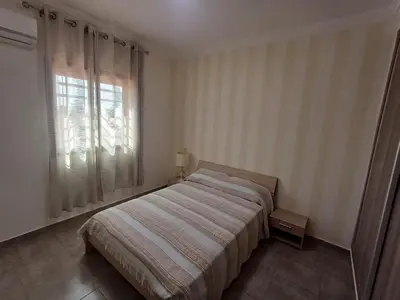 a bedroom with a bed and a large window at Cosy 2-bedroom apt in Ourika Route in Marrakech