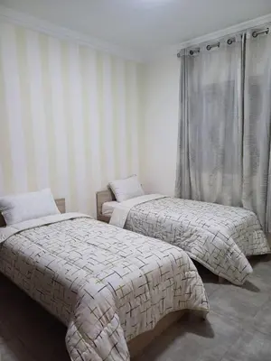 two beds in a room with striped walls at Cosy 2-bedroom apt in Ourika Route in Marrakech