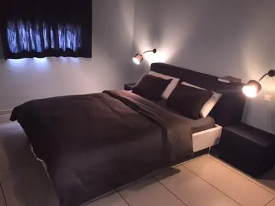 a bedroom with a large bed with two lights on it at Apartment with Private Rooftop & Jaccuzzi in Marrakech
