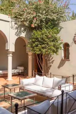 a living room with a couch and a tree at Résidence AYDA Riad Villa Hanane in Marrakech