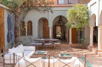 a patio with a couch and a table and chairs at Résidence AYDA Riad Villa Hanane in Marrakech