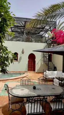 a patio with a table and chairs and a pool at Résidence AYDA Riad Villa Hanane in Marrakech