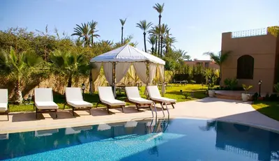 a group of chairs and a gazebo next to a pool at Villa Palmeraire Marrakech, Private pool, Private Hamam in Marrakech