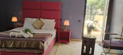 a bedroom with a large bed with a red headboard at Villa Palmeraire Marrakech, Private pool, Private Hamam in Marrakech