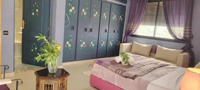 a bedroom with a bed with purple walls and a window at Villa Palmeraire Marrakech, Private pool, Private Hamam in Marrakech