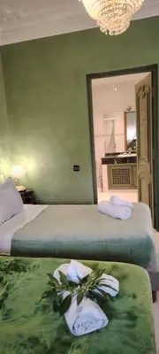 a bedroom with two beds with towels and a mirror at Villa Palmeraire Marrakech, Private pool, Private Hamam in Marrakech