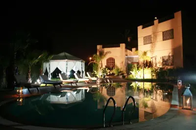 a hotel with a swimming pool at night at Villa Palmeraire Marrakech, Private pool, Private Hamam in Marrakech