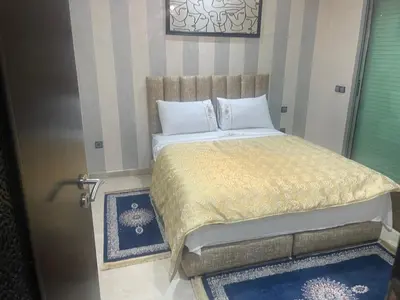 a bedroom with a bed and a door with a window at LA PERLE ANDALOUSE Quartier HIVERNAGE in Marrakech