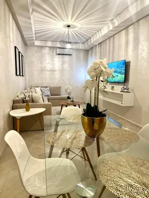 a living room with a couch and a table and chairs at La perle d'atlas appartement in Marrakech