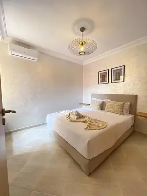 a bedroom with a large white bed and a ceiling at La perle d'atlas appartement in Marrakech