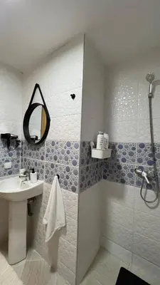 a bathroom with a sink and a shower with a mirror at La perle d'atlas appartement in Marrakech