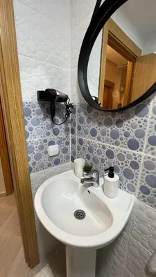a bathroom with a sink and a mirror at La perle d'atlas appartement in Marrakech