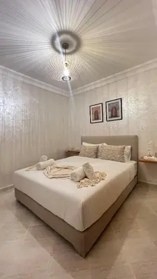 a bedroom with a large bed with a ceiling at La perle d'atlas appartement in Marrakech
