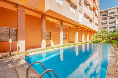 a swimming pool in front of a building at Elegant 2-BR, Pool And Parking Hivernage Centre in Marrakech