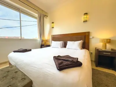 a hotel room with a large bed with towels on it at Elegant 2-BR, Pool And Parking Hivernage Centre in Marrakech