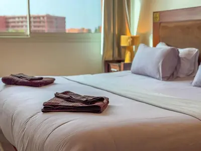 a hotel room with two towels sitting on a bed at Elegant 2-BR, Pool And Parking Hivernage Centre in Marrakech