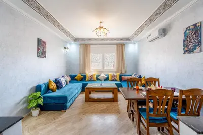 a living room with a blue couch and a table at L'essentiel au soleil piscine parking in Marrakech