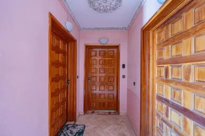 a hallway with a wooden door and a chandelier at L'essentiel au soleil piscine parking in Marrakech