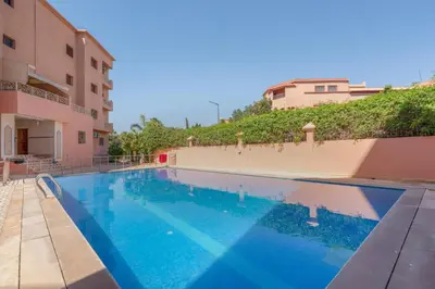 a large swimming pool next to a building at L'essentiel au soleil piscine parking in Marrakech