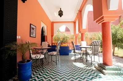 a patio with tables and chairs in a building at Villa Marrakchia - Palais d'hôtes in Marrakech