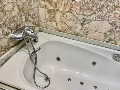 a white bath tub with a shower in a bathroom at Appartement Gueliz in Marrakech