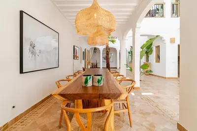 a dining room with a wooden table and chairs at Riad Dar Tonka in Marrakech