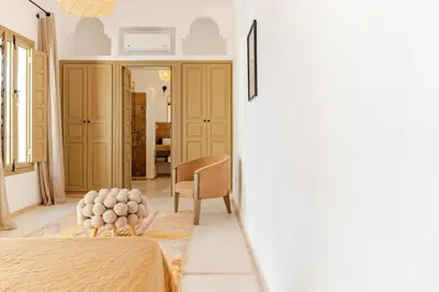 a bedroom with a bed and a chair in a room at Riad Dar Tonka in Marrakech