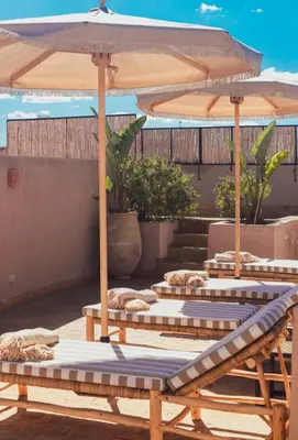 a group of tables with umbrellas on a patio at Riad Dar Tonka in Marrakech