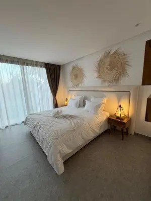 a bedroom with a large bed and two windows at Imagine Villa in Marrakech
