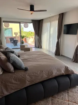 a bedroom with a large bed with a ceiling fan at Imagine Villa in Marrakech