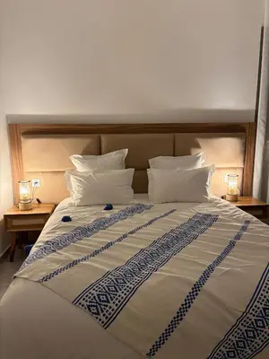 a large bed with white pillows and two night stands at Imagine Villa in Marrakech