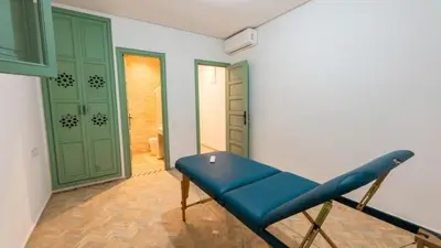 a blue chair in a room with green doors at Riad DAR ELMA NOI in Marrakech