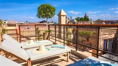 a balcony with two chairs and a table on it at Riad DAR ELMA NOI in Marrakech